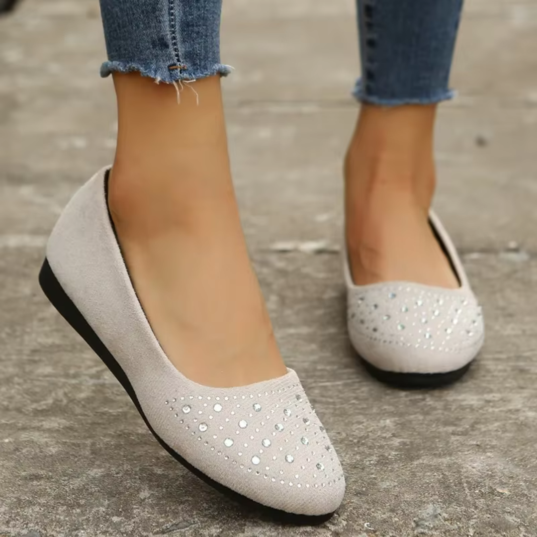 Ballerine blanche vue de côté, bout pointu orné de strass et semelle noire