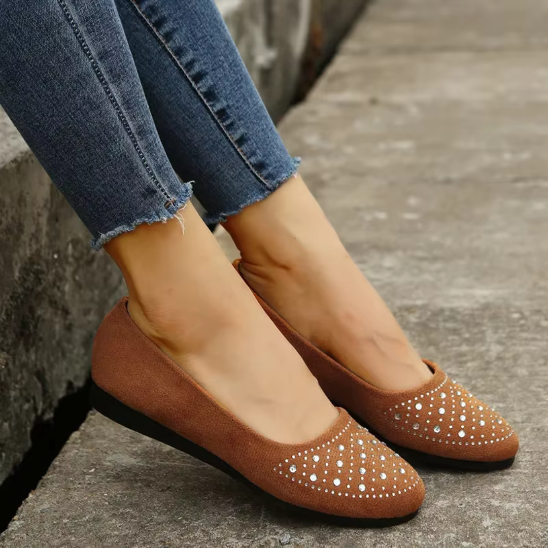 Ballerines marron à strass sur l'empeigne, semelle plate noire, portées avec un pantalon bleu