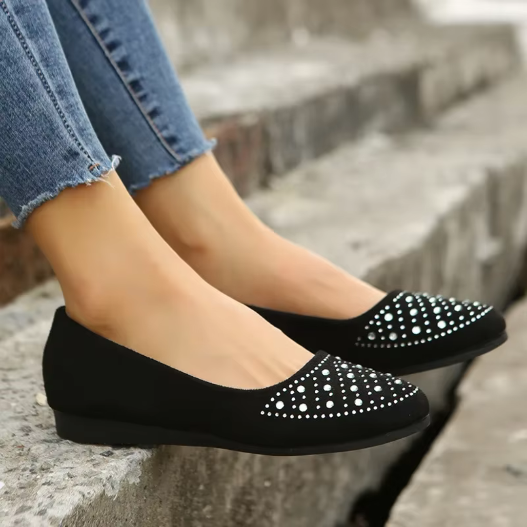 Ballerine noire vue de profil, semelle plate et strass sur l'avant du pied