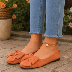 Ballerines femme orange à grand noeud, portées avec un pantalon clair à bords effrangés