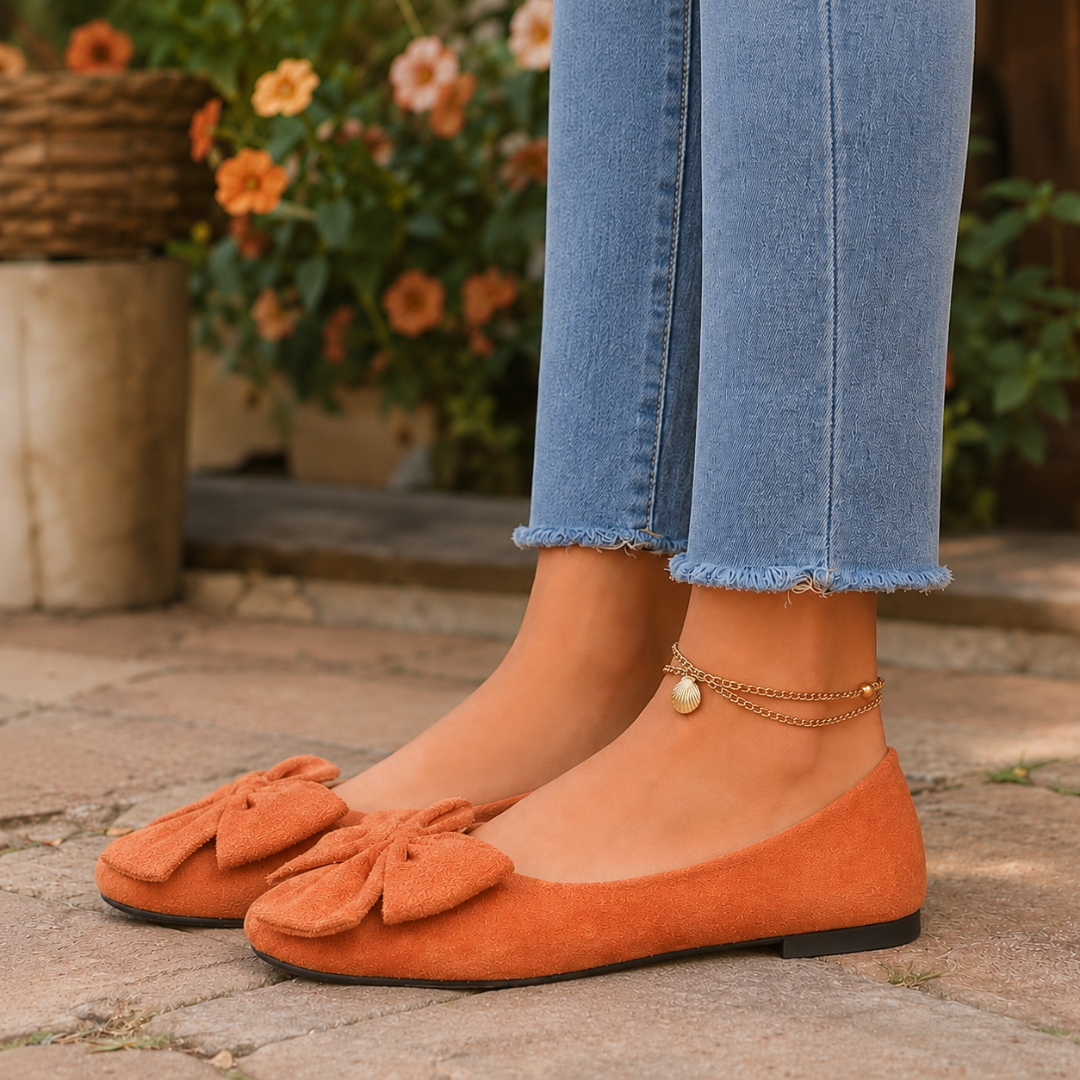 Ballerines plates orange vues de trois quarts, noeud volumineux sur le bout rond