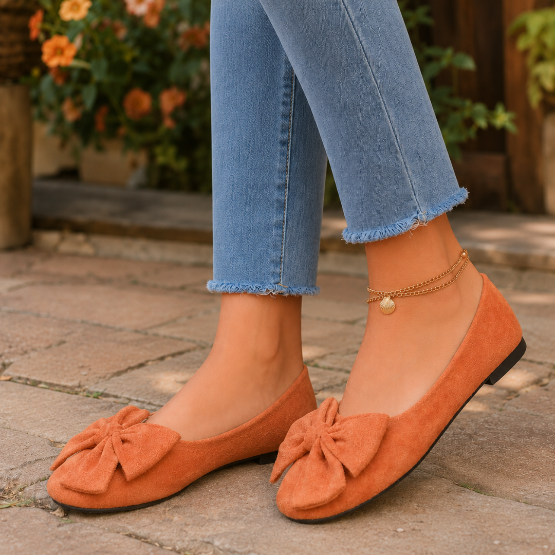Paire de ballerines orange en gros plan, noeuds froncés posés sur l'avant