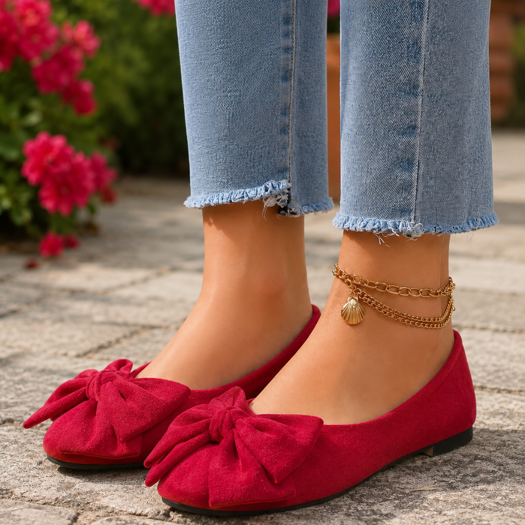 Ballerines femme rouges à noeud, portées avec un pantalon clair et une chaîne dorée