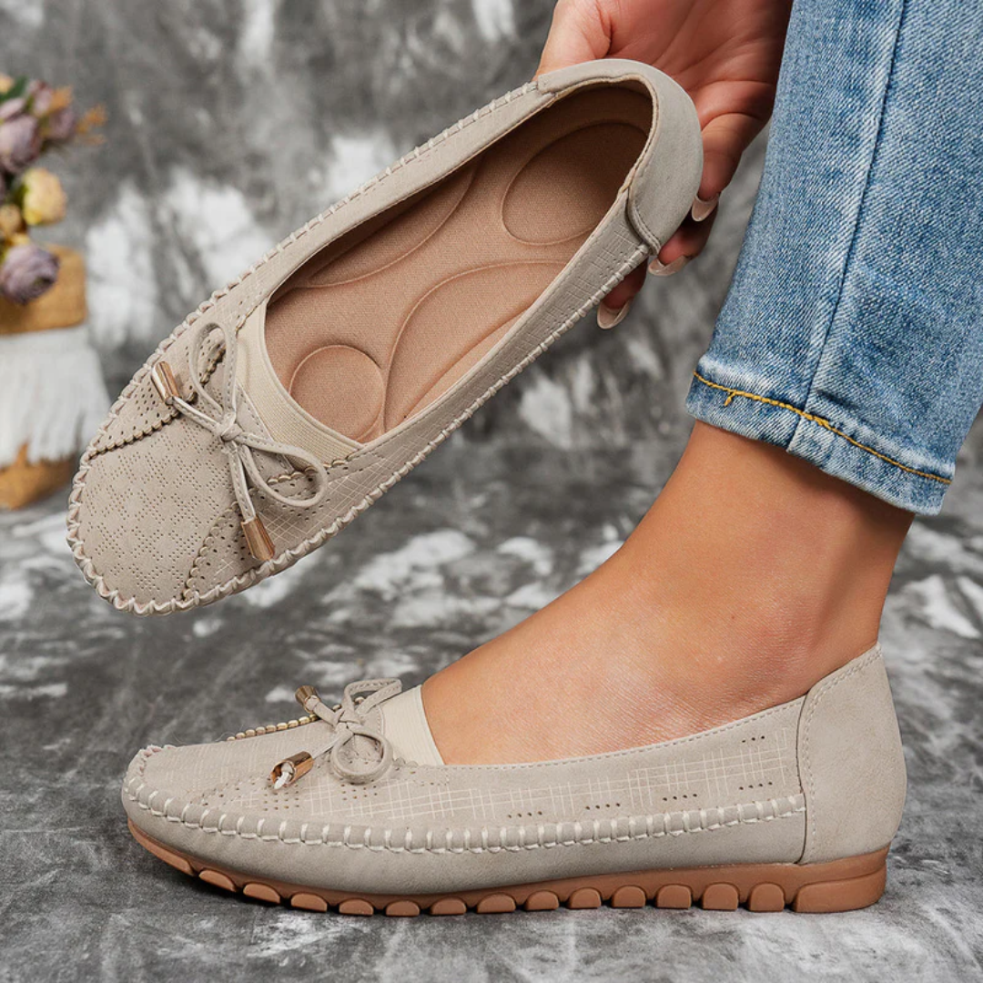 Ballerines Selena beige tenues dans la main, vue de la semelle rembourrée