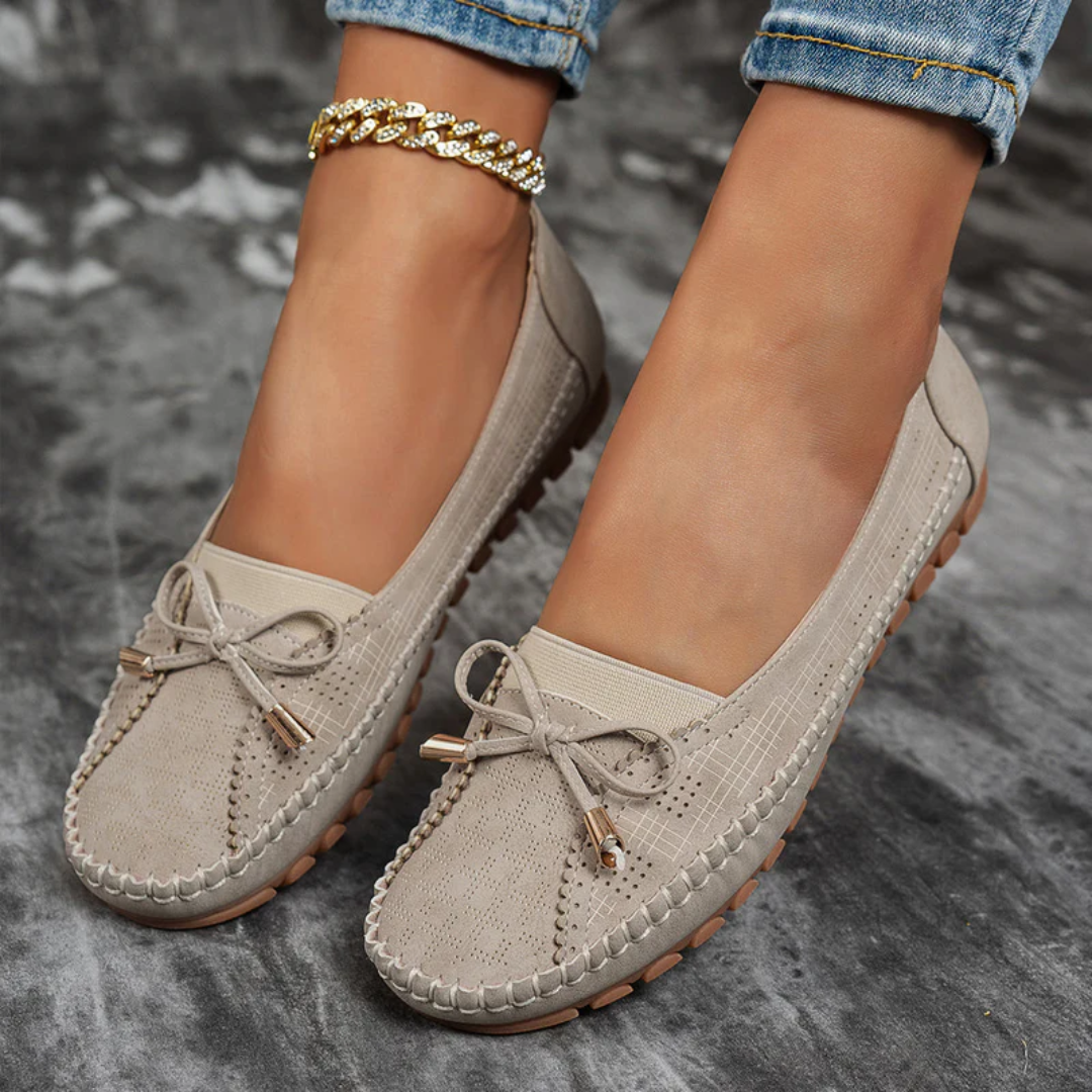 Ballerines Selena beige portées avec un jean, vue latérale nœud doré