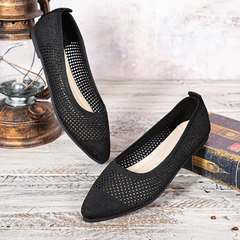 Paire de ballerines noires ajourées bout pointu vue de dessus sur fond bois