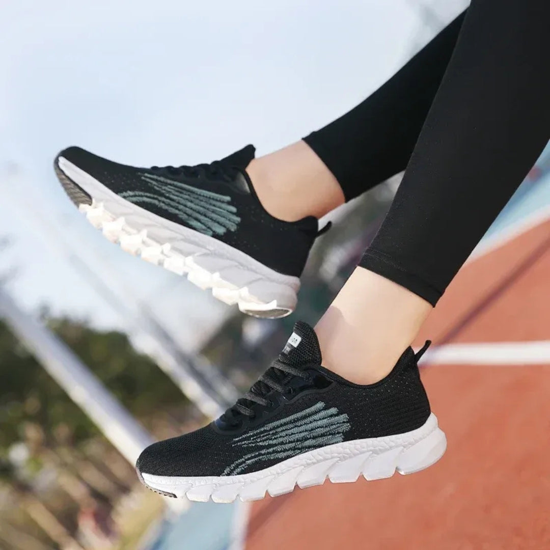Basket femme noire avec semelle blanche portée sur piste vue lacets