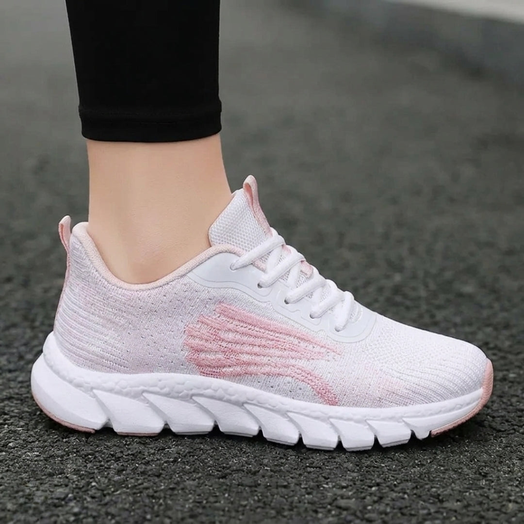 Basket femme rose portée sur piste de course rouge vue rapprochée