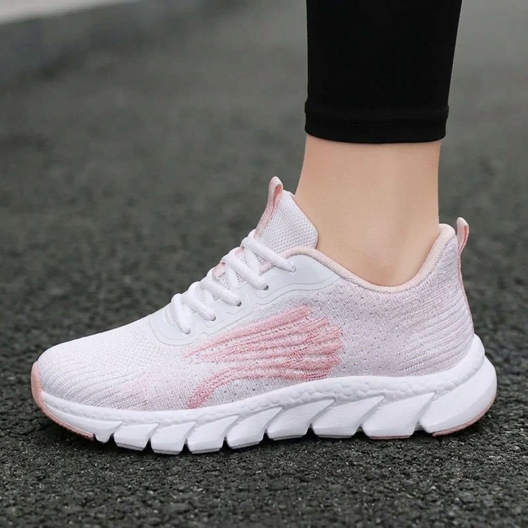 Basket femme rose portée sur piste de course rouge vue rapprochée