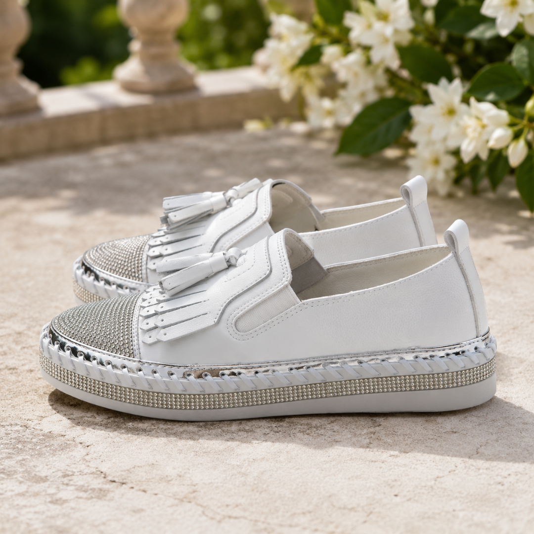 Détail des franges et des pampilles sur les baskets blanches à plateforme