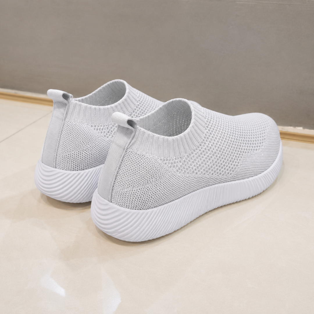 Vue arrière des baskets gris clair, tirants au talon et semelle blanche épaisse