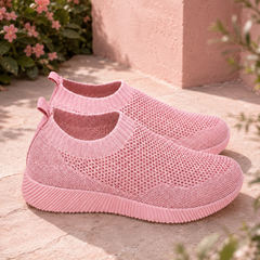 Baskets femme rose clair posées au sol, tige ajourée et tirant au talon