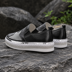 Vue de dos des baskets noires, plateforme blanche et bordure brillante contrastée