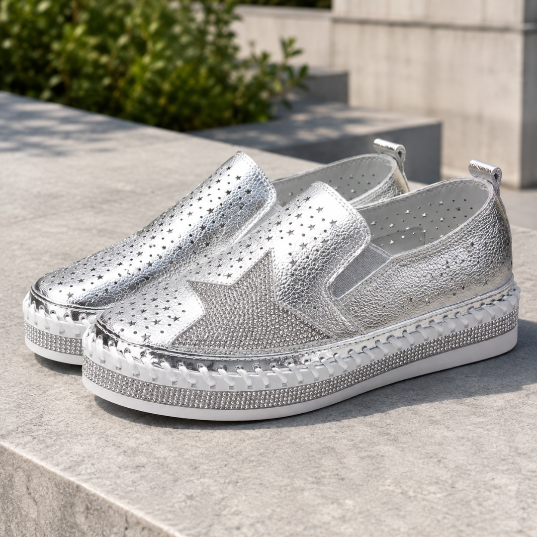 Paire de baskets femme argentées brillantes posées sur une marche, plateforme épaisse blanche