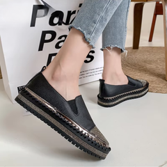 Baskets noires portées de profil, inserts élastiqués et plateforme brillante surpiquée