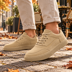 Baskets homme beige portées en pas, bout arrondi et lacets assortis visibles