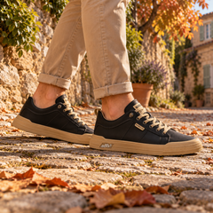 Baskets basses noires vues de profil, semelle contrastée et étiquette cousue sur le côté