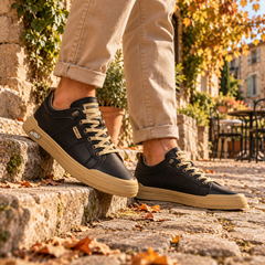 Baskets basses noires à œillets métalliques et bout arrondi, portées sur une marche