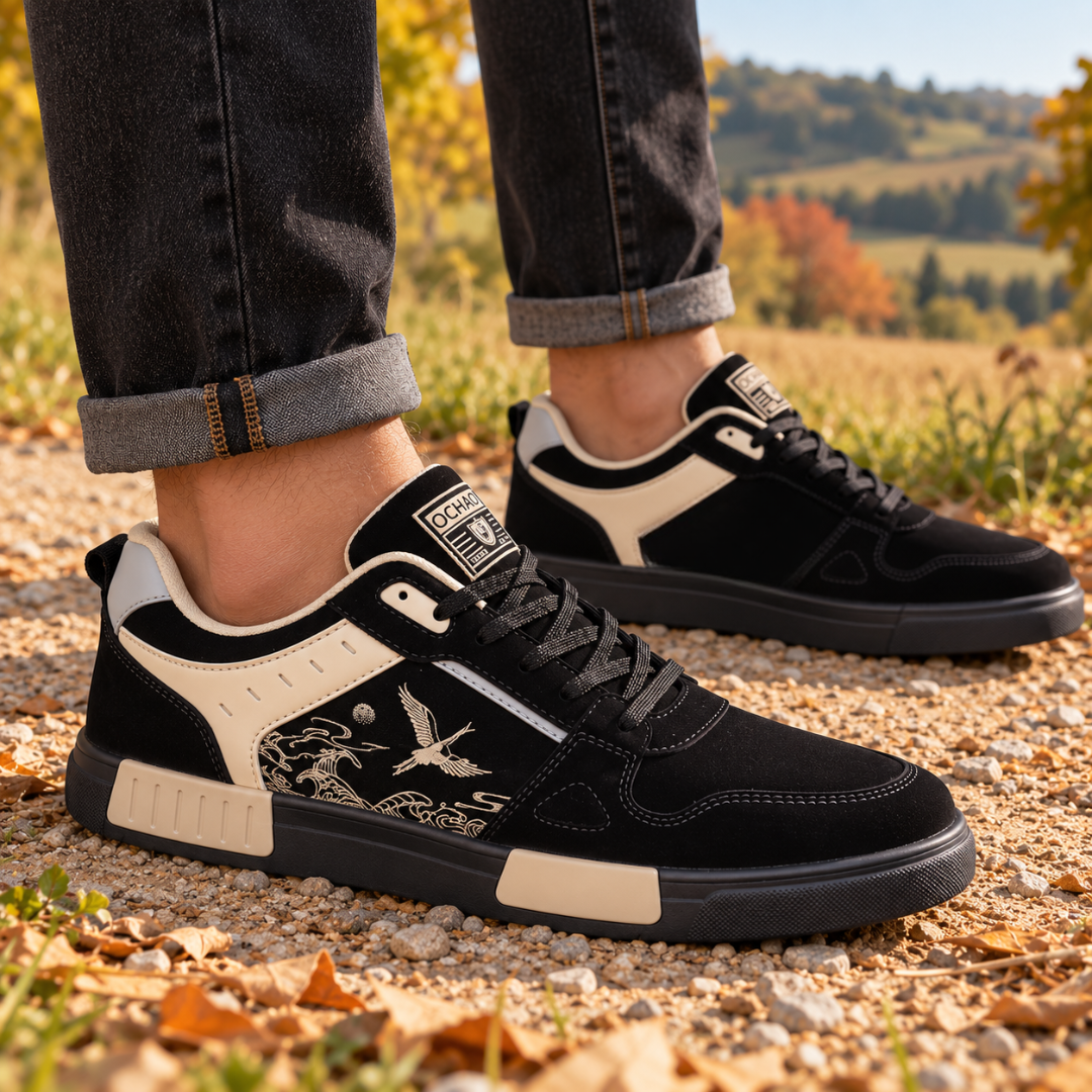 Baskets homme noires portées avec un pantalon foncé, imprimé grue et vagues visible