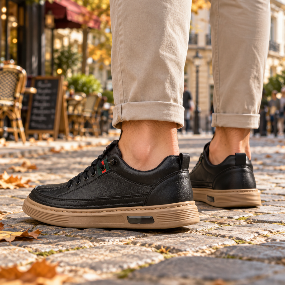 Baskets homme noires vues de côté, patte de tirage au talon et semelle striée