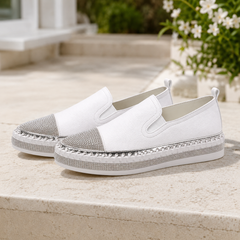 Paire de baskets blanches de trois quarts, bout pavé de strass et élastiques latéraux