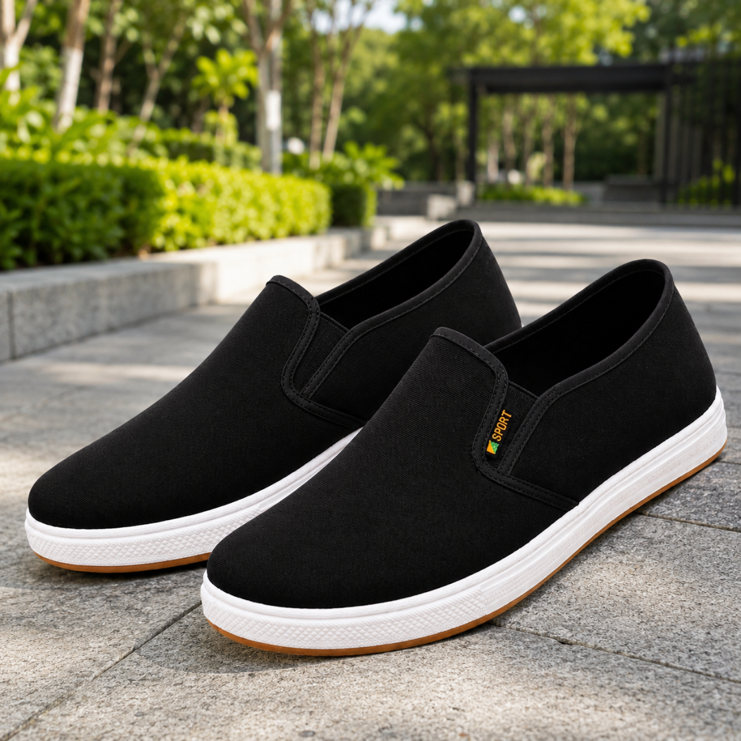 Baskets slip-on homme noir posées sur une terrasse en bois extérieure