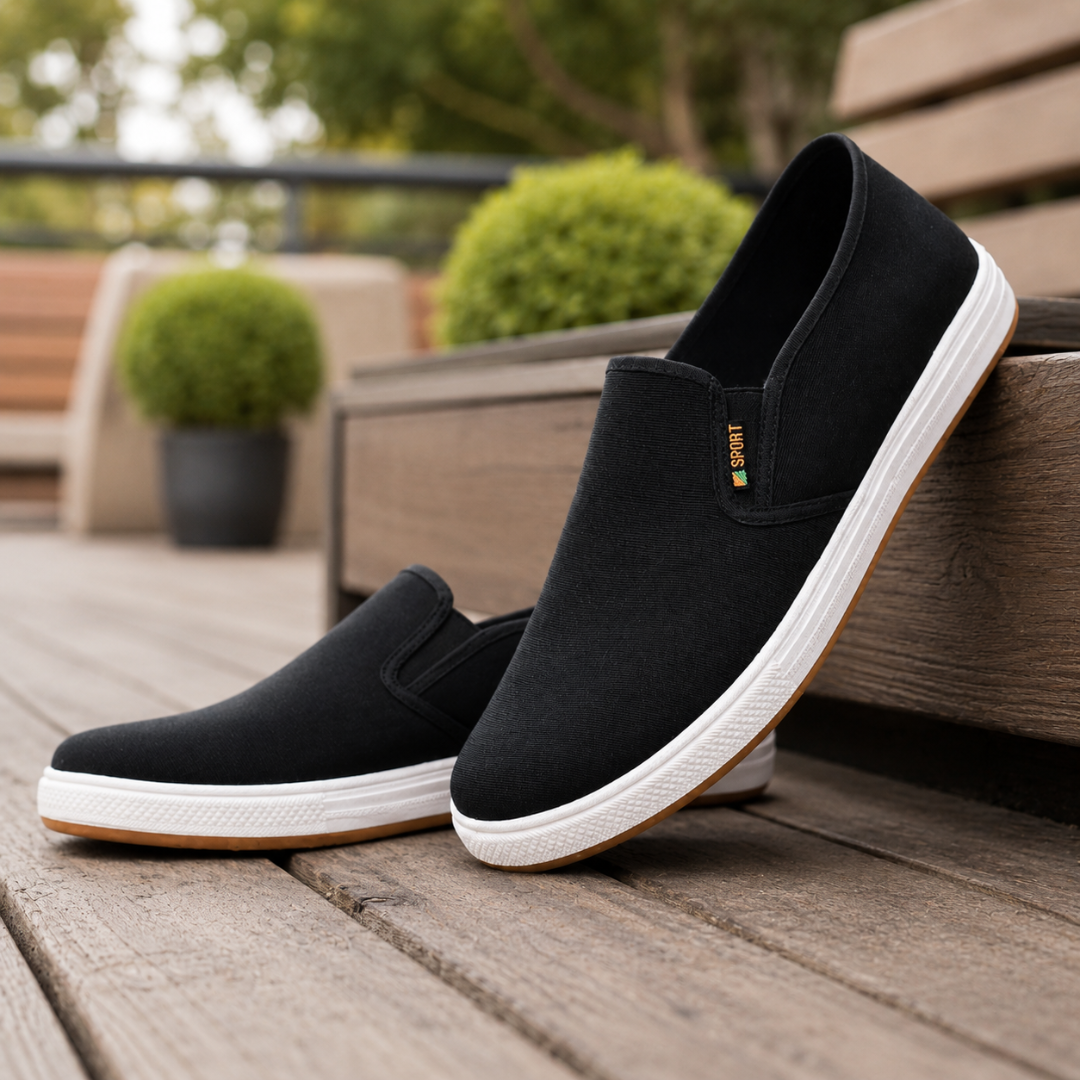 Baskets slip-on homme noir vue de profil avec verdure en arrière-plan