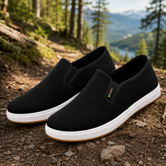 Baskets slip-on homme noir posées sur un chemin forestier naturel