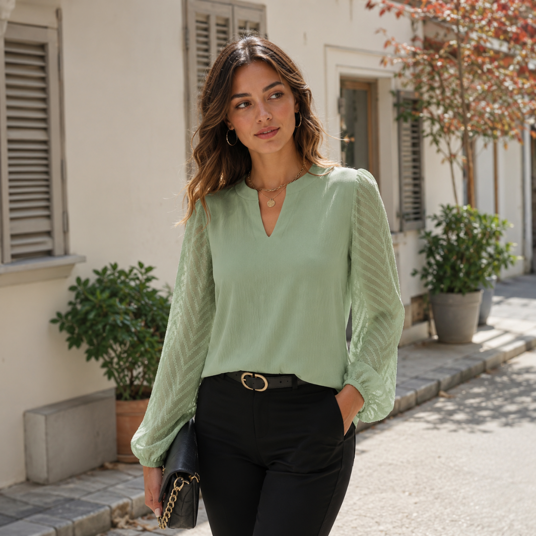 Blouse femme verte à col V fendu portée avec un pantalon noir ceinturé