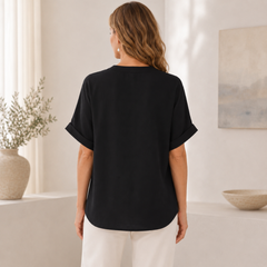 Gros plan sur le col V et la matière fluide de la blouse noire