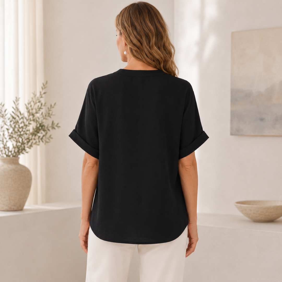 Gros plan sur le col V et la matière fluide de la blouse noire