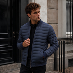 Blouson homme matelassé bleu porté ouvert, col montant côtelé et fermeture zippée