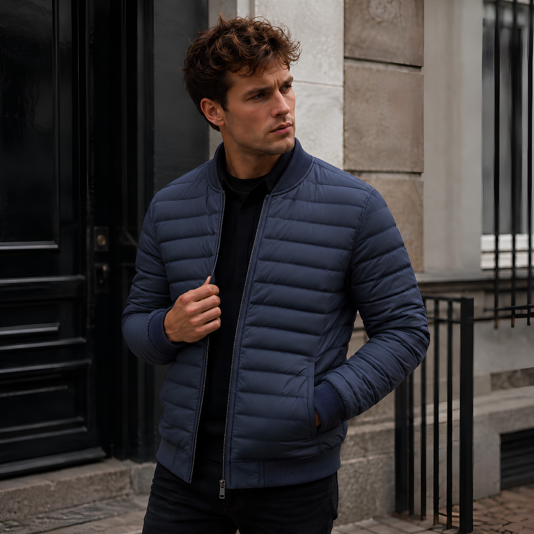 Blouson homme matelassé bleu porté ouvert, col montant côtelé et fermeture zippée