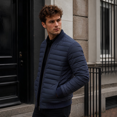 Blouson homme bleu matelassé de profil, poignets côtelés et col montant