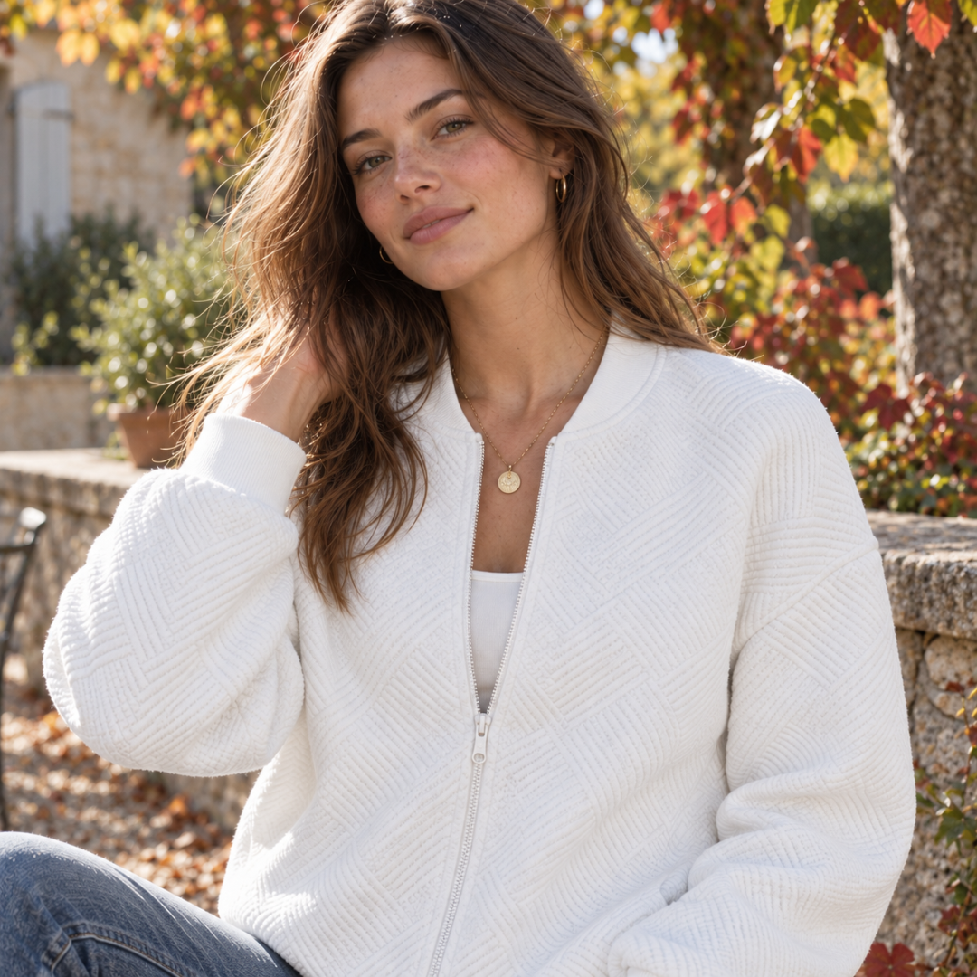 Gros plan du bomber blanc femme, glissière et motif géométrique visibles