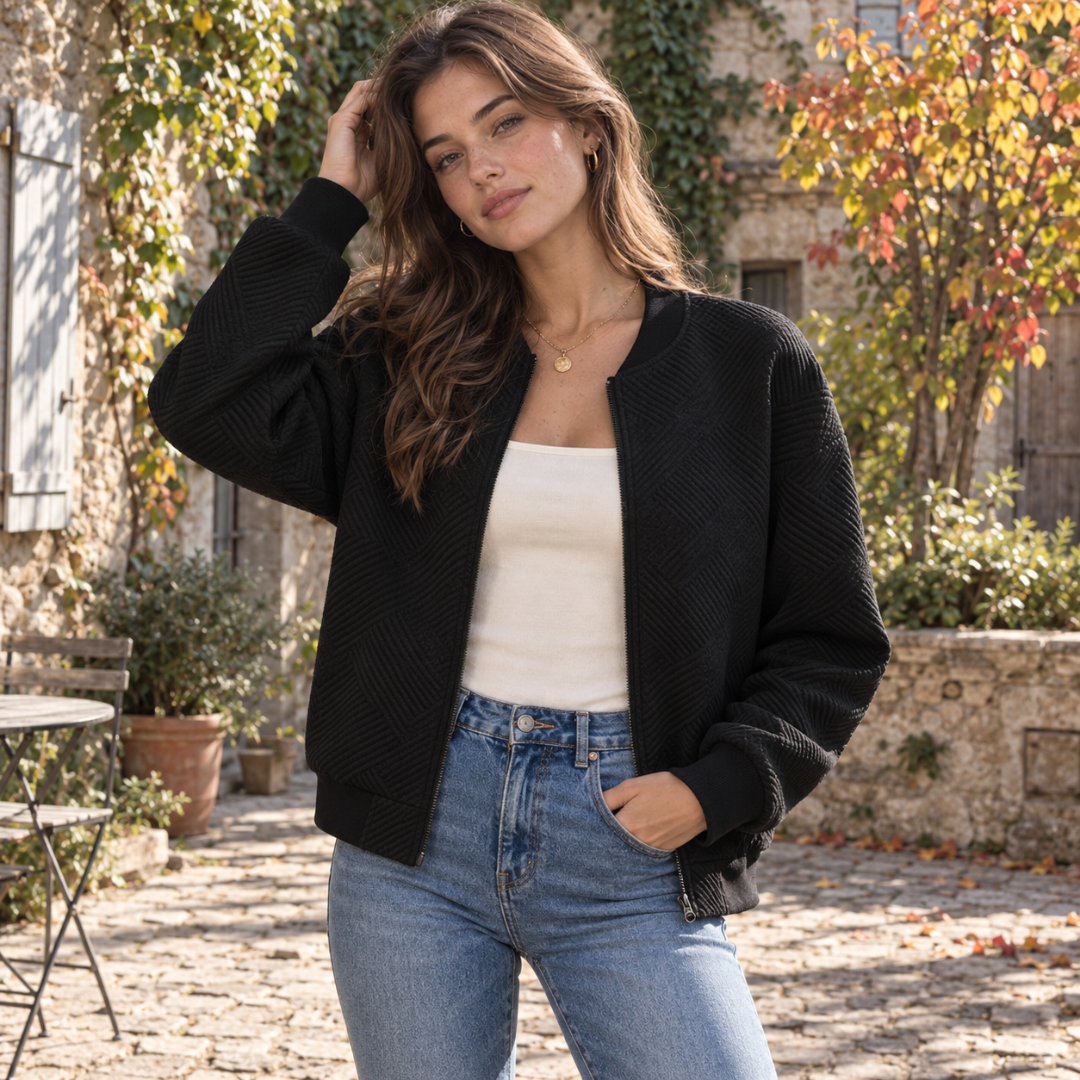 Bomber noir femme à motif géométrique en relief, zip ouvert sur un haut blanc