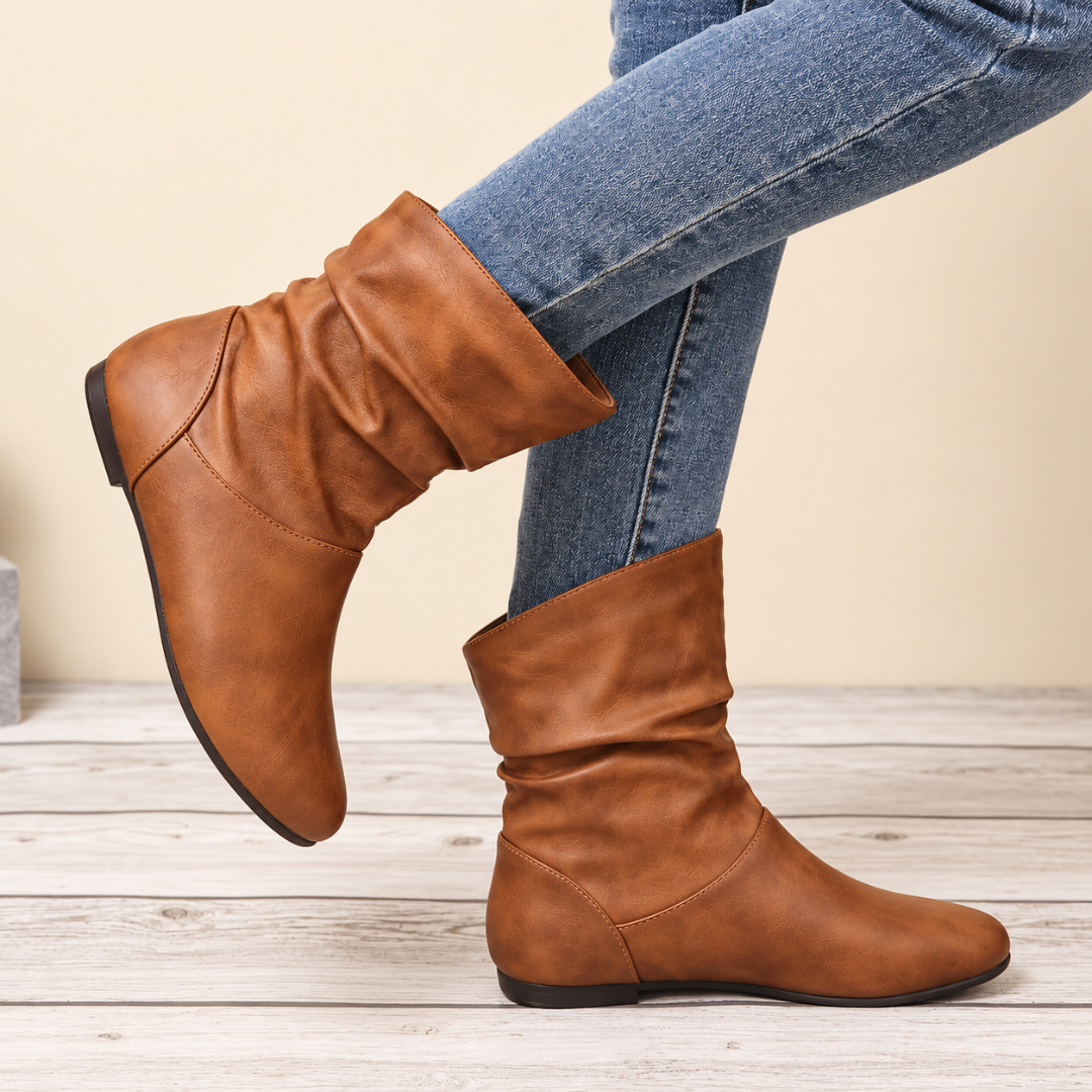 Bottes femme marron drapées portées avec un pantalon bleu, talon plat