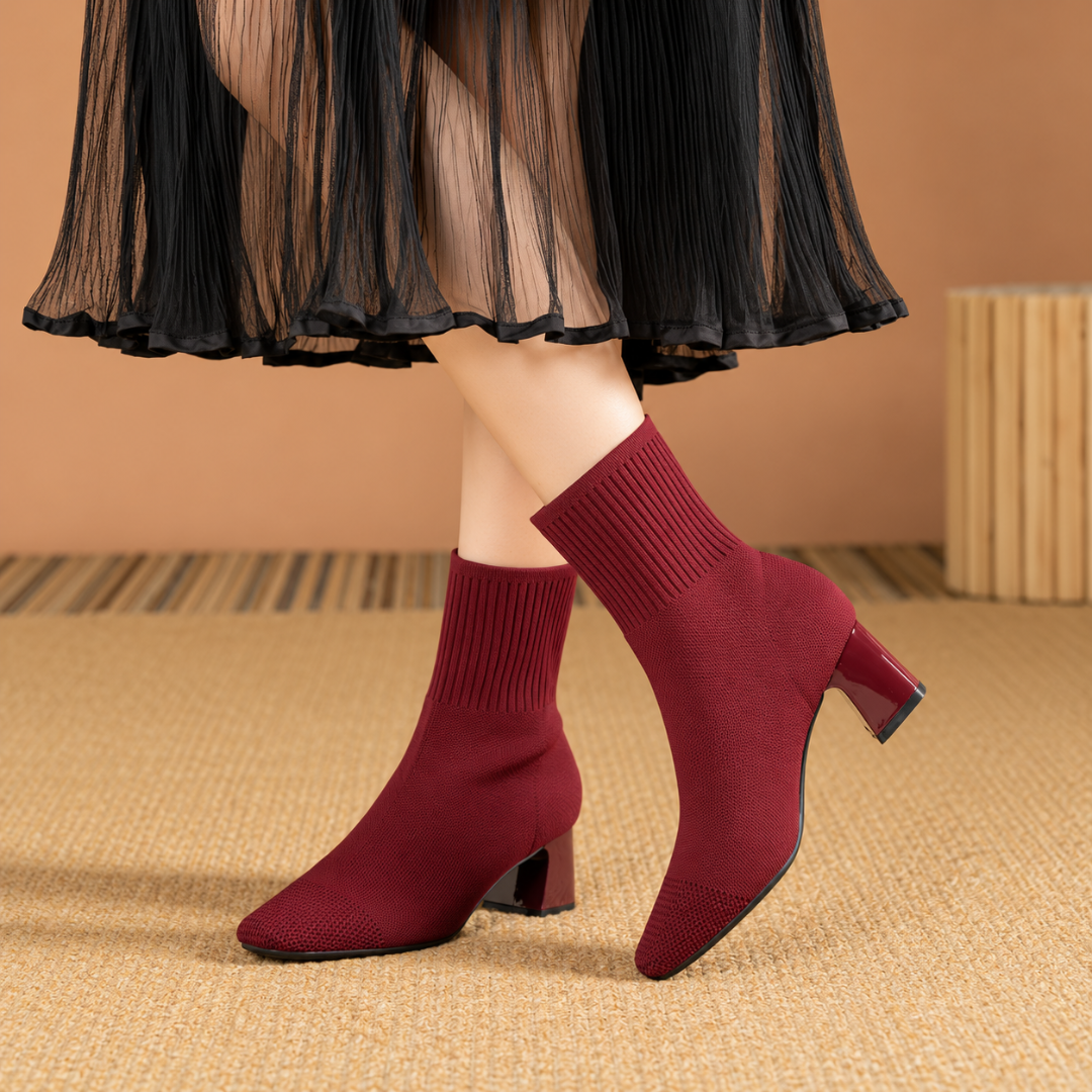 Bottines chaussette rouge foncé portées avec une jupe plissée noire, talon bloc