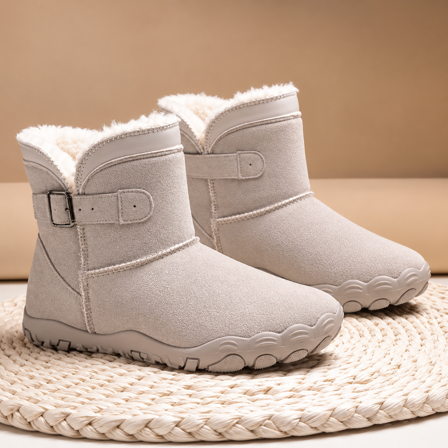 Paire de bottines ivoire vue de côté, boucle métallique et surpiqûres apparentes