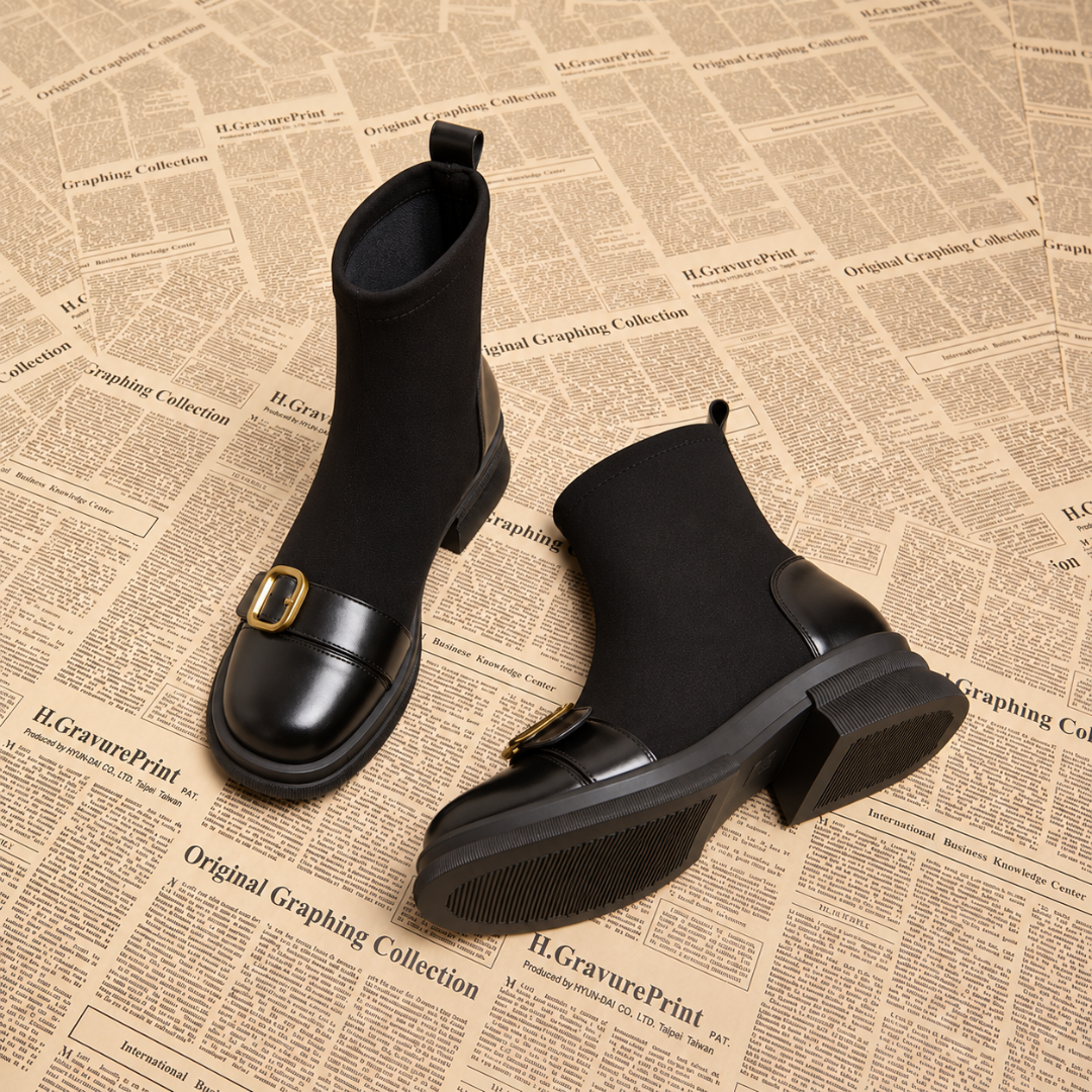 Bottines femme noires posées en diagonale, boucle dorée et talon bloc visibles