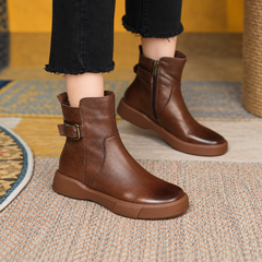 Bottines marron portées avec un pantalon foncé, boucle latérale et fermeture éclair visibles