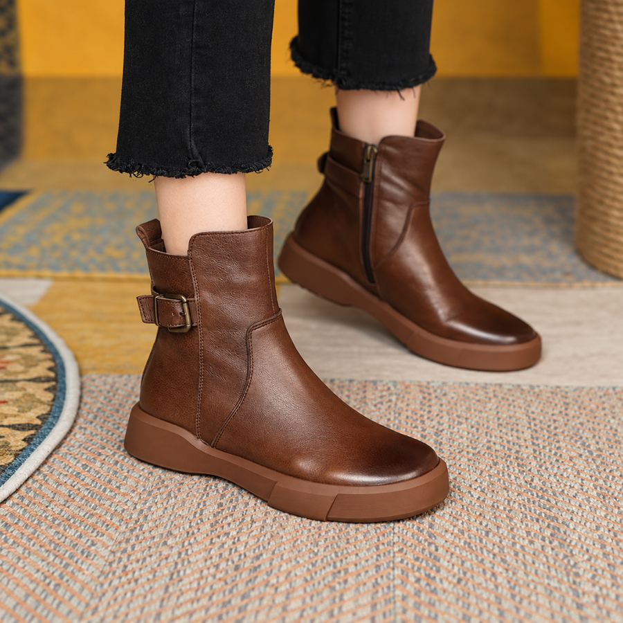 Bottines marron portées avec un pantalon foncé, boucle latérale et fermeture éclair visibles