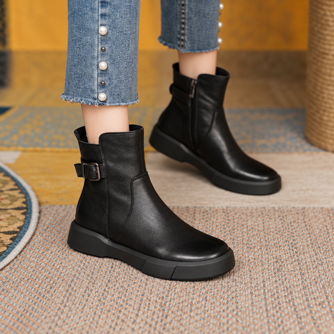 Bottines noires portées avec un pantalon clair, fermeture éclair sur le côté