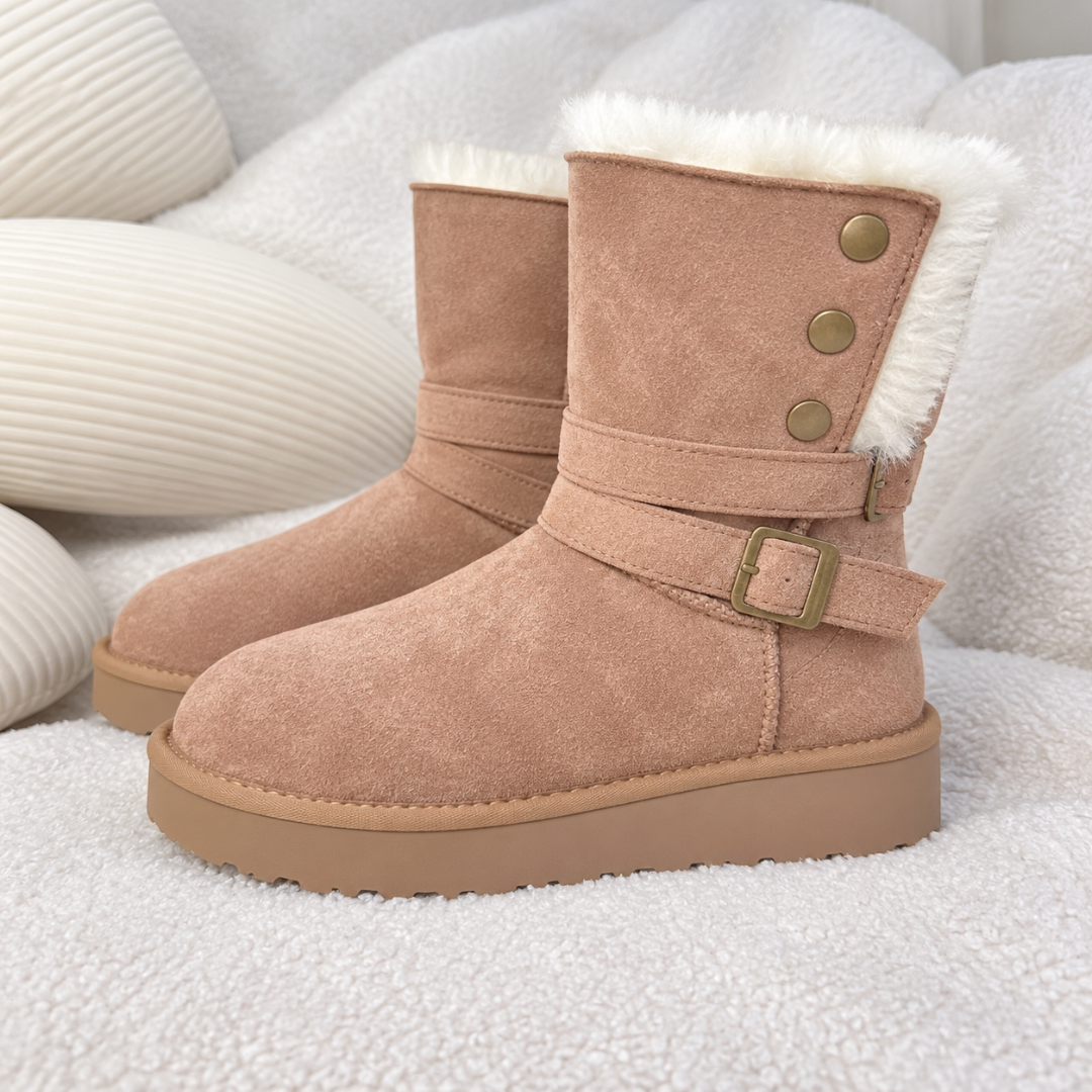 Gros plan sur la bride à boucle et les boutons des bottines beiges