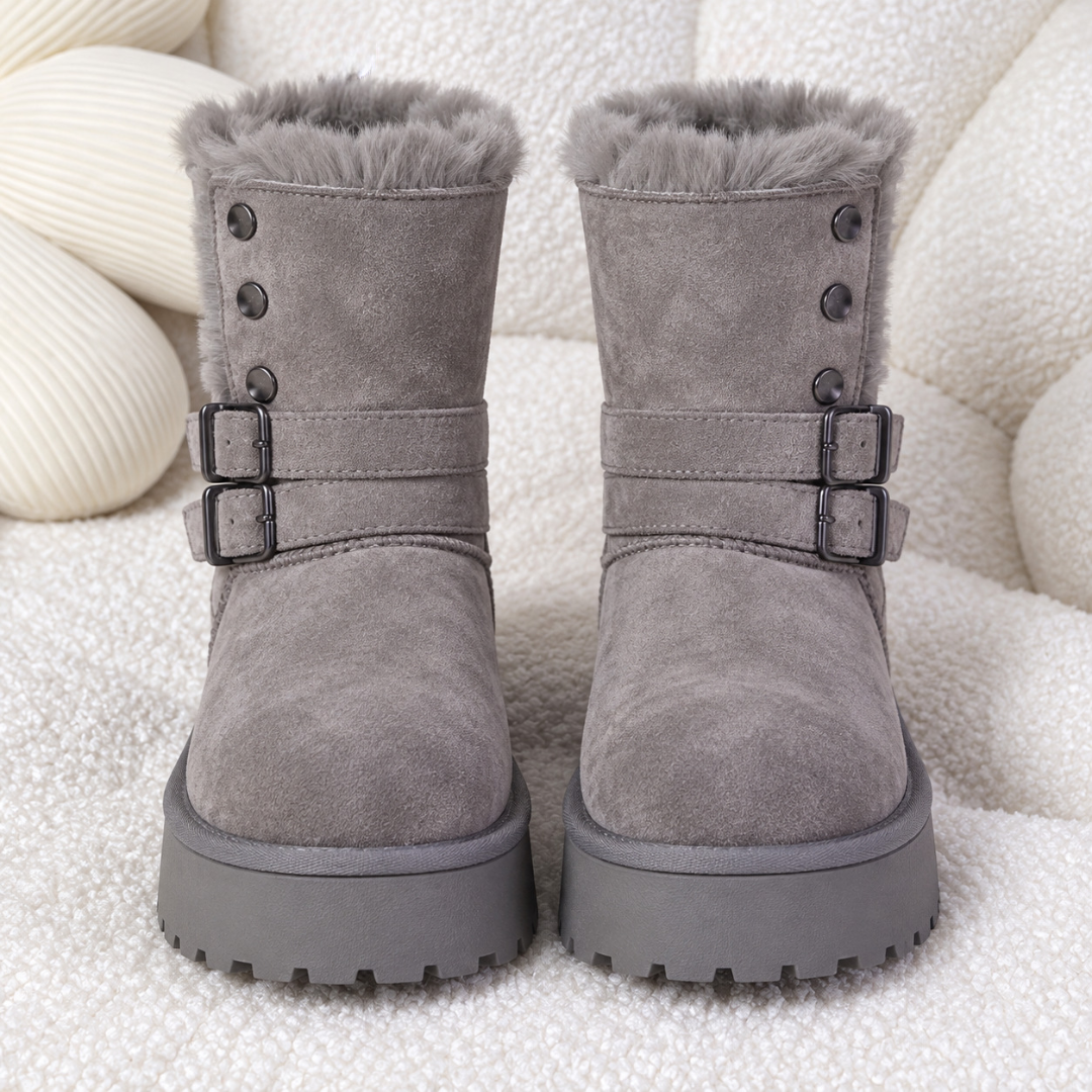 Bottines grises vues de face, revers duveteux et doubles boucles métalliques noires