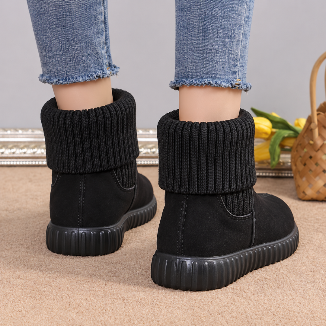 Vue arrière des bottines noires avec revers en maille et semelle épaisse noire