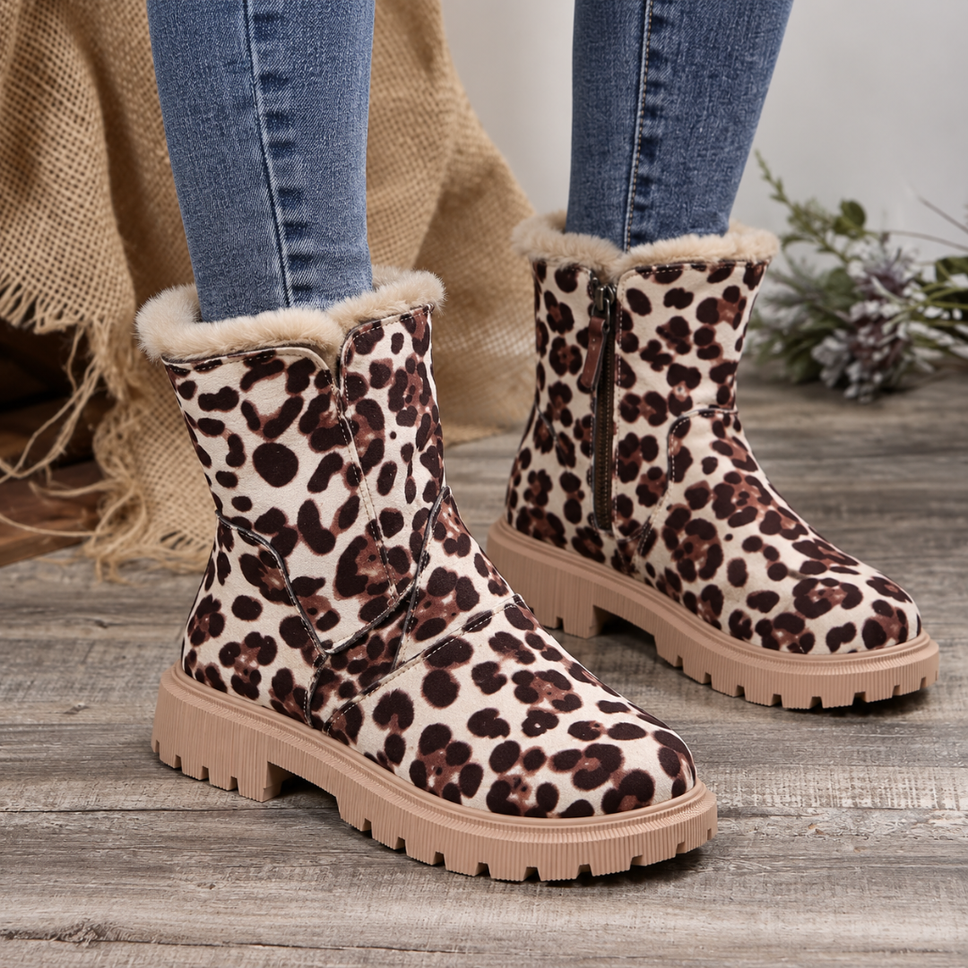 Bottines léopard portées avec un pantalon bleu, zip latéral et bout rond visibles