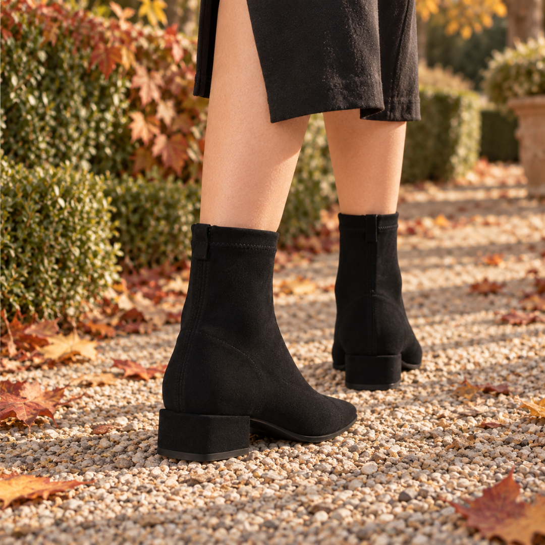 Vue arrière des bottines noires avec zip et talon bloc sur gravier