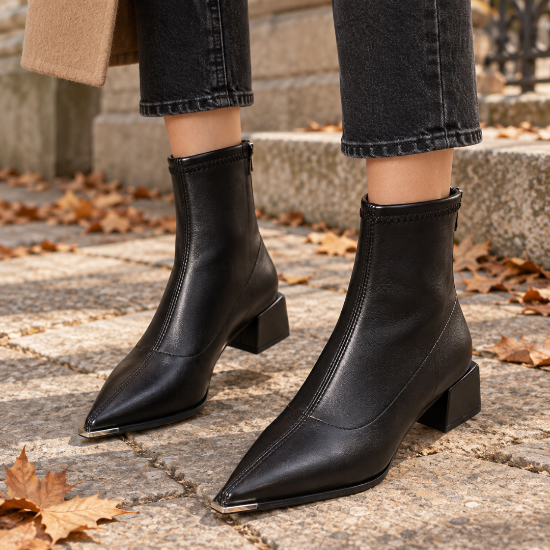 Bottines femme noires à bout pointu et embout métallique, portées avec un pantalon sombre