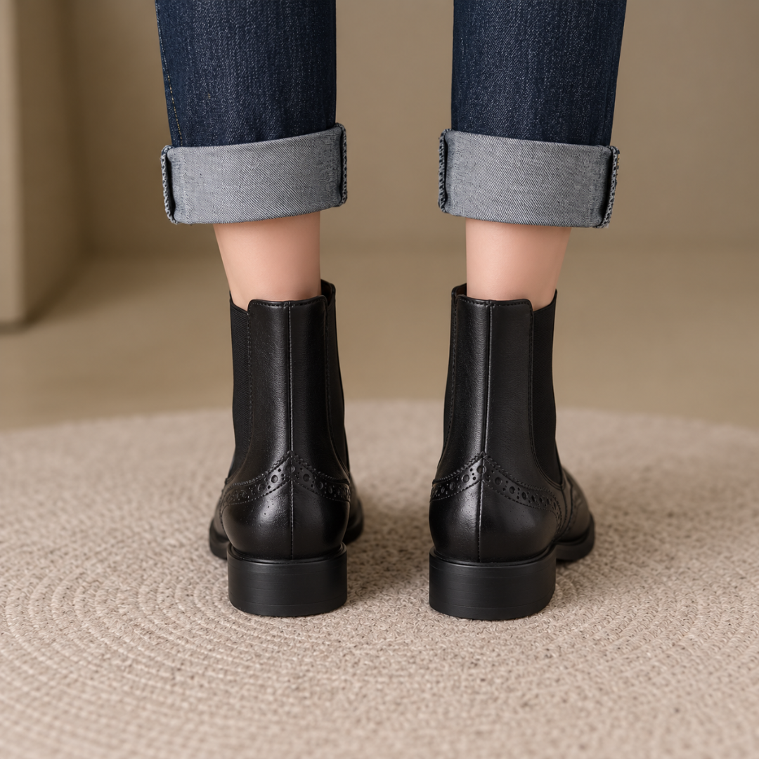 Arrière des bottines Chelsea noires avec couture centrale et détail brogue perforé